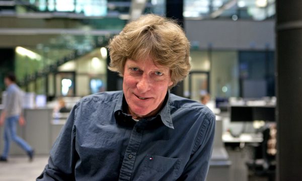 Portrait of a man sitting in a newsroom