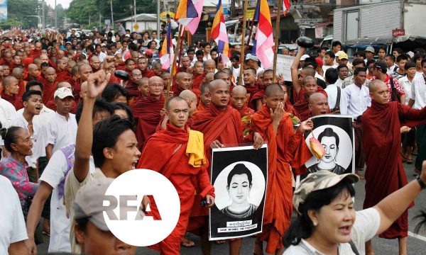 monks in red robes march in protest